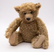 An early 20th-century Steiff blond plush Teddy bear, with button to ear, black boot button eyes,