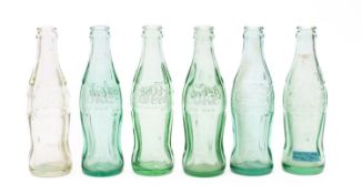 A collection of six WWII period Coca Cola bottles discarded by the American forces stationed on