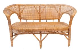 A rattan worked settee, second half 20th century; the backrest with curved ends,