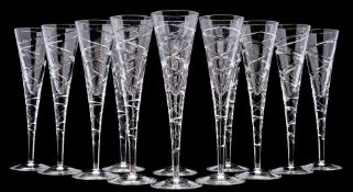Twelve contemporary 'cross swirl' champagne flutes, with cut decoration to the bowl and stem,