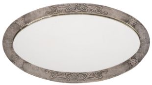 An Arts and Crafts silver painted and metal sheet oval mirror,