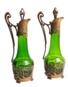 A pair of Continental gilt spelter mounted green glass ewers in Art Nouveau style,