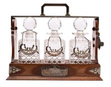 A Victorian oak and brass mounted tantalus, by Betjemann of London,