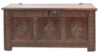 An early 18th century and later carved oak coffer, with a plain hinged moulded top,