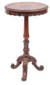 A Victorian walnut circular occasional table; with a stylised leaf apron,