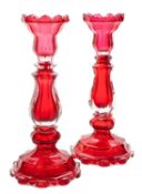 A pair of Bohemian ruby and clear glass candlesticks of faceted baluster form,