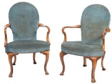 A pair of walnut and upholstered elbow chairs in George II style,
