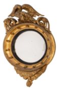 A Regency carved giltwood circular convex wall mirror;