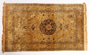 A Kashmir silk rug, the light brown field with a central circular indigo pole medallion,
