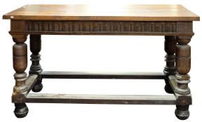 A 17th-century oak rectangular serving table, with a later top; with a fluted foliate frieze,