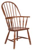 A 19th-century elm and ash stick back Windsor elbow chair; with a shaped solid seat,