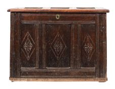 A 17th-century oak rectangular coffer; with a plain triple paneled hinged top,