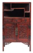 A Chinese red lacquered side cabinet, 20th century; with an arrangement of open shelves above,