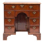 A walnut and feather banded kneehole desk, 18th Century and later,