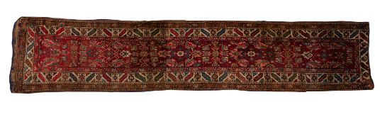 A Kurdish runner, the red field with an all over geometric medallion and leaf design,