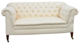 An Edwardian mahogany framed Chesterfield settee; with a single drop end,