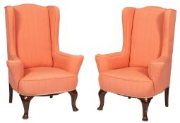 A pair of wingback armchairs in George II style, 20th century; with wing back and outscrolled arms,