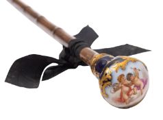 A Continental porcelain mounted cane the handle painted with cherubs amongst clouds within a gilt