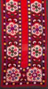 A North East Persian silk bed cover embroidered in the form of a prayer arch with panels of