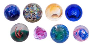 Six Caithness glass paperweights, together with a Liskeard glass example and one other.