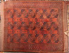 WITHDRAWN A Turkoman carpet, the brick red field with three rows of quartered octagons,