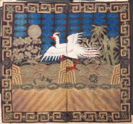A Chinese silk and metal thread embroidered rank badge in the form of a phoenix amongst waves and