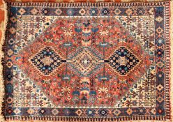 A Southern Persian rug, the brick red field with triple hooked and stepped lozenge medallions,