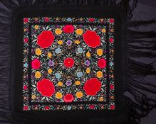 A Chinese silk embroidered and tasselled cover worked overall with brightly coloured peony sprays