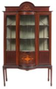 An Edwardian mahogany and inlaid display cabinet; of bowed breakfront outline,