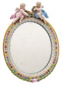 A Meissen porcelain wall mirror of oval form applied with ribbon tied laurel and surmounted with