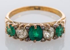 An emerald and diamond ring, the three oval cut emeralds with old cut diamonds in between,