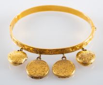 A hinged bangle, with engraved foliate decoration and four hinged locket pendants,