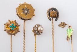 Five gemset pins, including inter alia a diamond cluster pin, total estimated diamond weight ca. 0.