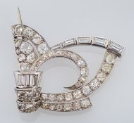A diamond brooch, the scrolled openwork brooch set with old brilliant cut and baguette cut diamonds,