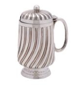 A Victorian silver mustard pot, maker Edward Hutton, London 1889, of swirled reeded form,