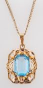 An octagonal, step-cut blue paste pendant, stamped '585', and a curb-link chain marked '15CT',