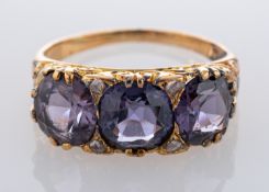 A purple, probably synthetic spinel, three-stone ring, with rose-cut diamond spacers,