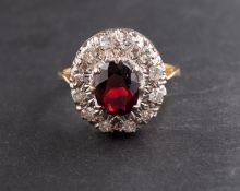 An oval, mixed-cut garnet and round, brilliant-cut diamond cluster ring,