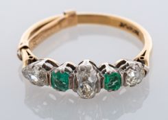 An emerald and diamond five stone ring, claw set with an old mine claw set diamond to the centre,