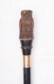 An early 20th century walking cane with carved owl handle,