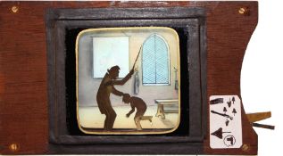 'Schoolmaster caning boy' [arm and cane move up and down] Maker unknown (7 x 4 1/8 x 3/4 inches),