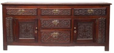 An oak dresser base, early 18th century and later carved; the top,