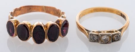 A three stone diamond ring, claw and millegrain set with three brilliant cut diamonds; and a five