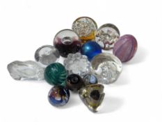 A collection of fourteen assorted glass paperweigh