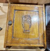 20th century oak wall cupboard with relief flower moulding to panelled door, 30cm wide