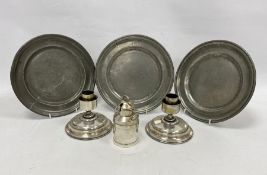 Three pewter plates, a pair of candlestick holders and a sauce pot in the form of a milk churn (1