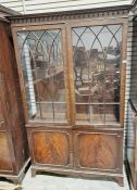 Mahogany glazed display cabinet with two glazed doors raised over a two-door cupboard, with fitted