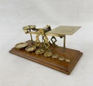 Set of late 19th century Sampson Mordan and Co. postal scales, with seven graduated weights on oak