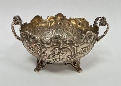 19th century foreign silver circular-shaped two-handled dish, repousse decorated with cherubs,