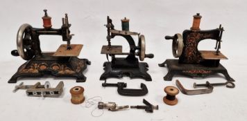 Collection of four early 20th century child's sewing machines, tinplate and cast iron, black with